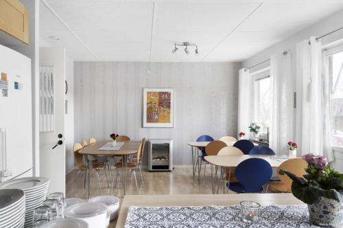 a dining room with blue chairs and tables at Aurora Bed & Breakfast in Simrishamn