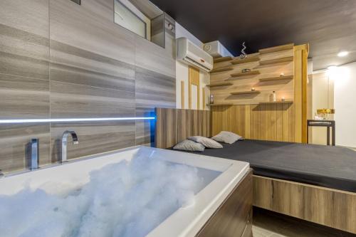 - une chambre avec une baignoire et un lit dans l'établissement Private Wellness Apartment, à Trebnje