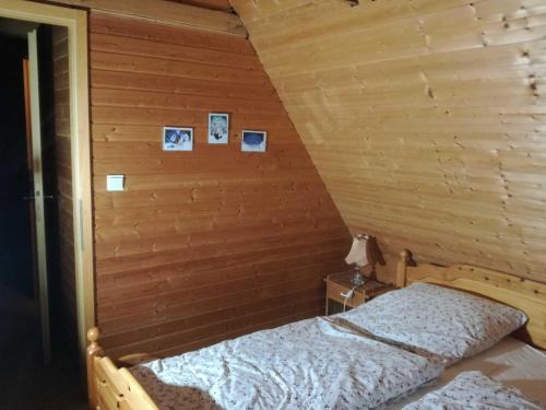 a bed in a wooden room with pictures on the wall at Ferienhaus Suda in Timmendorfer Strand