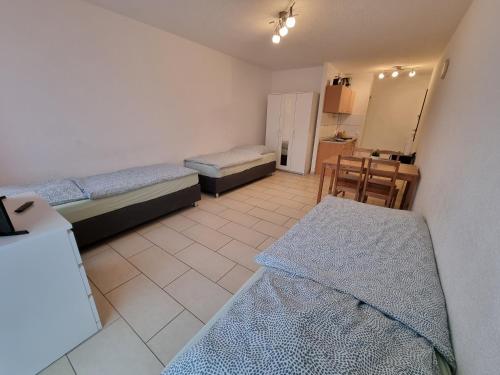 a room with two beds and a table in it at Workers-Sleep-Station in Cologne