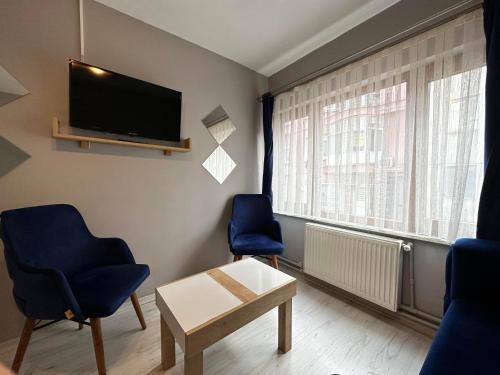 ein Wohnzimmer mit 2 Stühlen und einem Flachbild-TV in der Unterkunft beydağı suit in Istanbul