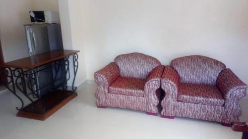 a living room with two chairs and a table at KITWE PEMBENI APARTMENTS in Mombasa