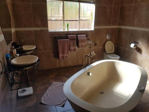 a bathroom with a tub and a toilet and a sink at La Picasso in Ermelo