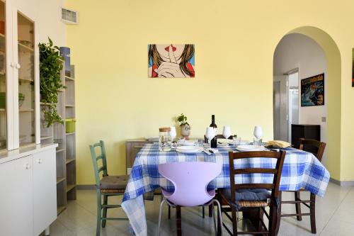 a dining room with a table with a purple chair at Casa Aurora con giardino in Bari Sardo