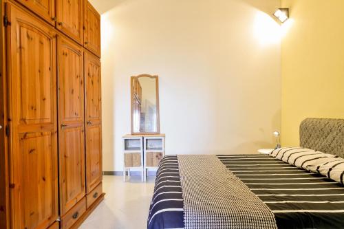 a bedroom with a bed with a dresser and a mirror at Casa Aurora con giardino in Bari Sardo