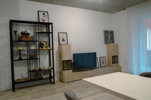 a living room with a tv and a table at Cozy Apartment in Floreşti