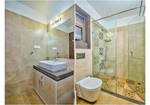 een badkamer met een wastafel, een toilet en een douche bij Telferk Acron Seawinds Apartment- Baga in Calangute
