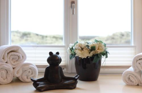 eine Statue auf einem Tisch neben einer Vase mit Blumen in der Unterkunft Ruarklef in Kampen