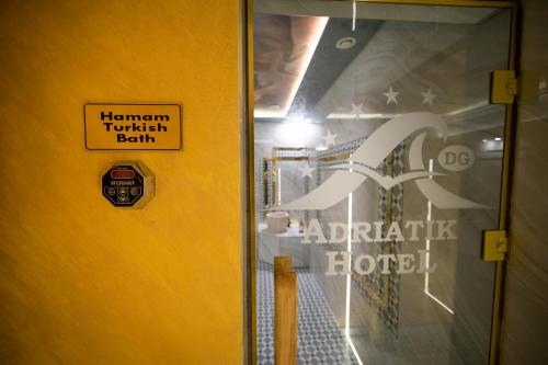 a glass door with a sign on the door of a restaurant at Adriatik Hotel, BW Premier Collection in Durrës