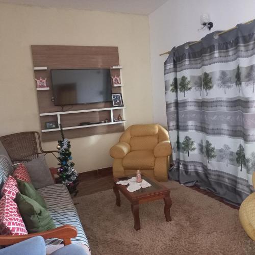 een woonkamer met een bank, een stoel en een tv bij Hospedaje por día.. in Encarnación