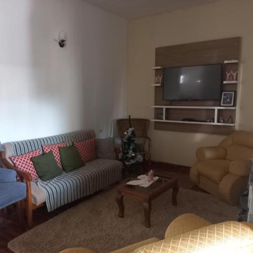 een woonkamer met een bank en een tv bij Hospedaje por día.. in Encarnación