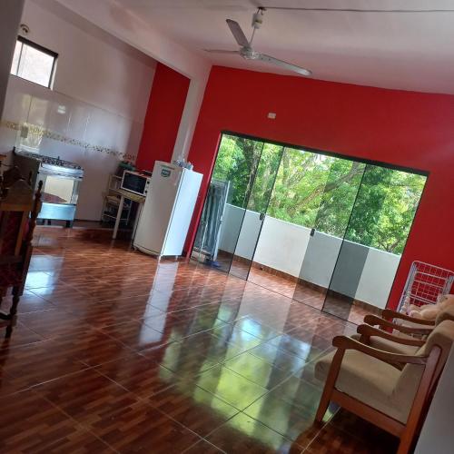a living room with red walls and a large window at Hospedaje por día.. in Encarnación