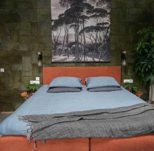 een slaapkamer met een groot bed met 2 kussens bij ForRest Suites in Ermelo