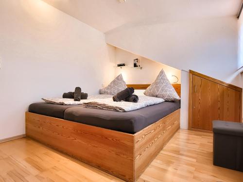 een slaapkamer met een bed met een houten bedframe bij Ferienwohnung Beim Ivo in Roßhaupten