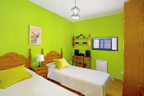 Dormitorio verde con 2 camas y ventana en Finca Tropical, en Ingenio