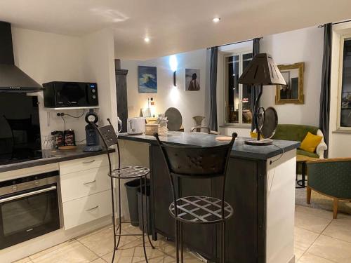 - une cuisine avec un comptoir et des chaises dans la chambre dans l'établissement Dupleix au Fil du Canal, à Narbonne