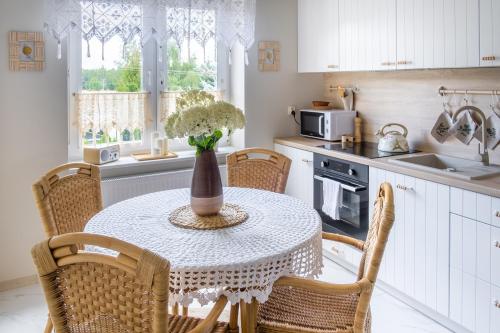 a kitchen with a table with a vase of flowers on it at Agroturystyka z Alpakami Mazury in Mrągowo