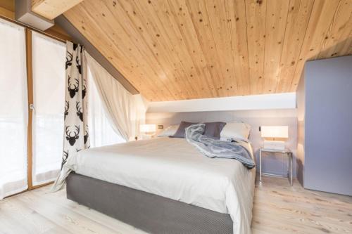 um quarto com uma cama e um tecto de madeira em Folgaria Top Rent em Folgaria