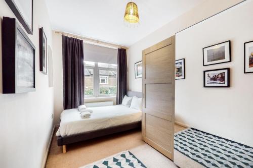 een kleine slaapkamer met een bed en een raam bij Charming 1 bedroom flat with parking in Brentford in Brentford