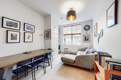 Charming 1 bedroom flat with parking in Brentford في برينتفورد: غرفة معيشة مع طاولة وأريكة