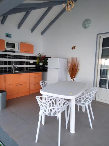 a kitchen with a white table and chairs at Résidence Fleur de Lys 1 in Petit-Bourg