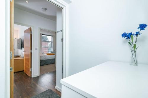 una habitación con un jarrón de flores azules en un mostrador en *20% off Monthly* St Albans City Centre Apartment en Saint Albans