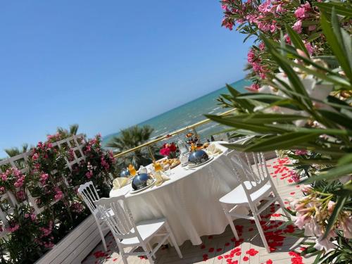 a table and chairs on a balcony with the ocean at Adriatik Hotel, BW Premier Collection in Durrës