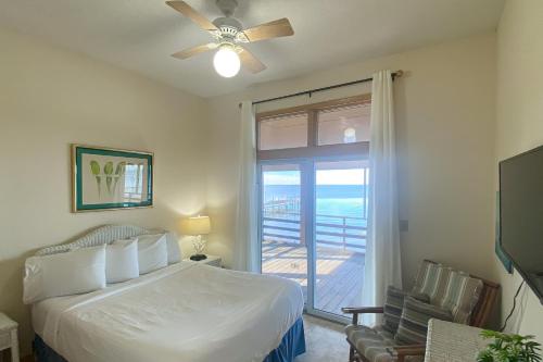 um quarto com uma cama e uma porta de vidro deslizante em Anchor's Aweigh em St. George Island