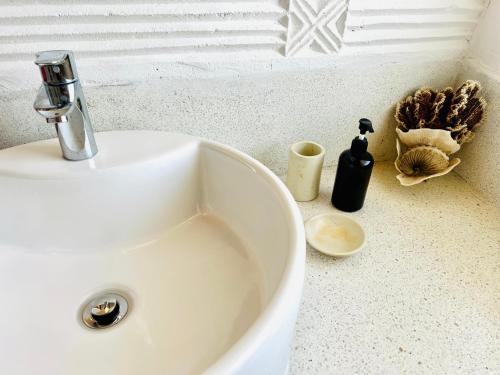 a white sink with a soap dispenser on a counter at Beba.Beach.House in Watamu