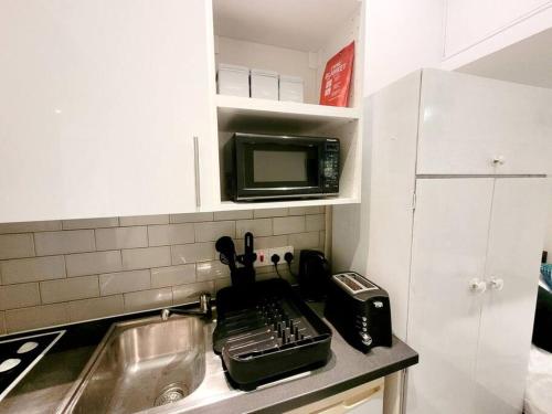 a small kitchen with a sink and a microwave at (S7) Great Studio Next To A Tube Station! in Harrow on the Hill