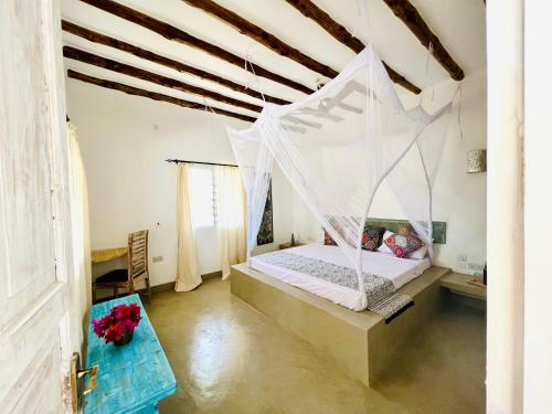 Schlafzimmer mit einem Bett mit Moskitonetz in der Unterkunft Beba.Beach.House in Watamu