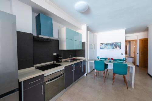 a kitchen with blue chairs and a counter top at Calypso in Cotillo