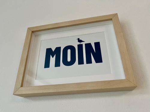 a picture frame with the word mom on a wall at Pension Blaue Nordseewelle in Neuharlingersiel