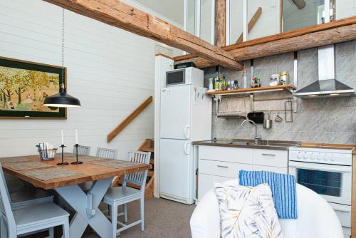 a kitchen with a table and a kitchen with a refrigerator at Seaside Cottage House nr 1, Saltvik Hudiksvall in Hudiksvall