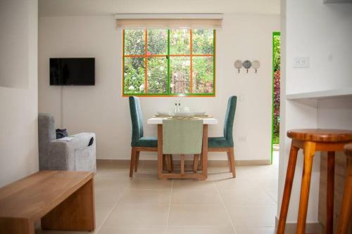 a dining room with a table and chairs and a window at Duplex Familiar Apartment Nature in Guatapé