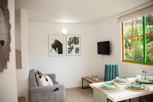 a living room with a table and a chair at Duplex Familiar Apartment Nature in Guatapé