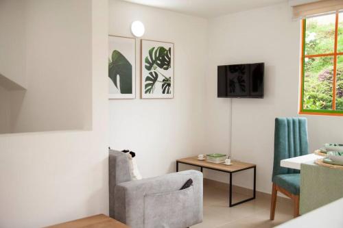 a living room with a chair and a table at Duplex Familiar Apartment Nature in Guatapé