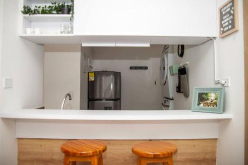 a kitchen with two stools and a counter with a refrigerator at Duplex Familiar Apartment Nature in Guatapé