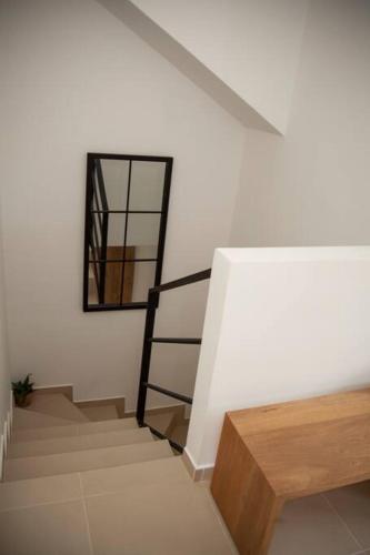 a staircase in a white room with a mirror at Duplex Familiar Apartment Nature in Guatapé