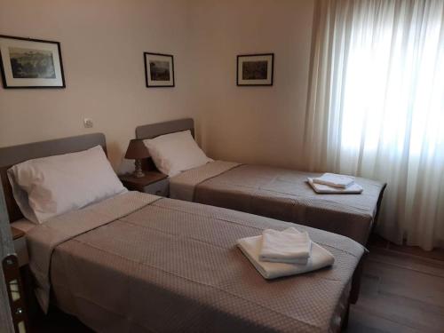 twee bedden in een hotelkamer met handdoeken erop bij Χαρά 