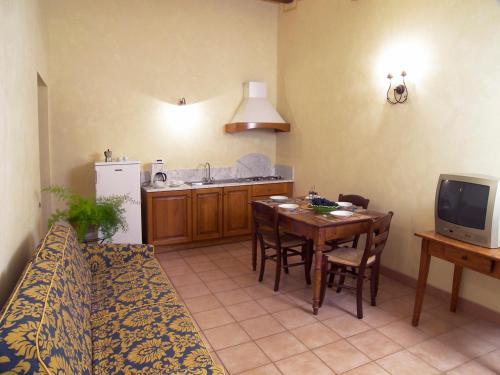 a living room with a table and a kitchen at Appartamento Gelsomino in San Miniato