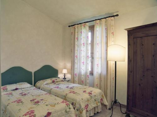 um quarto com 2 camas, um candeeiro e uma janela em Appartamento Begonia em San Miniato