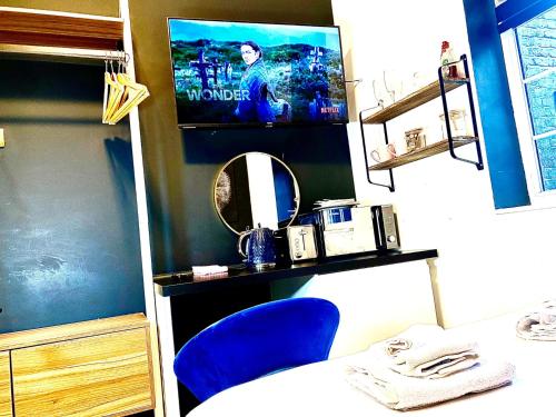 a room with two blue chairs and a tv at Duke and Duchess Apartments and Rooms - Private in Room Hot Tub Suites in London