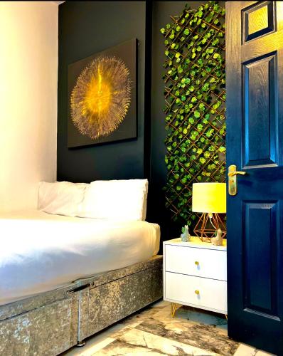 a bedroom with a bed and a wall with a picture at Duke and Duchess Apartments and Rooms - Private in Room Hot Tub Suites in London