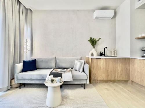 a living room with a couch and a table at Sol Marina Resort Wyspa Sobieszewska I - LoftAffair Collection in Wiślinka
