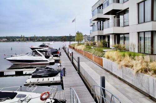 a group of boats docked next to a building at Sol Marina Resort Wyspa Sobieszewska I - LoftAffair Collection in Wiślinka