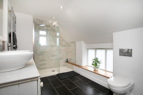 Baño blanco con lavabo y aseo en Central 4 Bedroom House en Derby