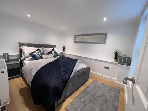 a bedroom with a bed with a black comforter at Gorgeous 2 floor 3 bed Apartment in St. Leonards