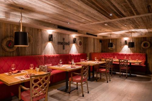 a restaurant with red booths and tables and chairs at Resort La Ginabelle in Zermatt