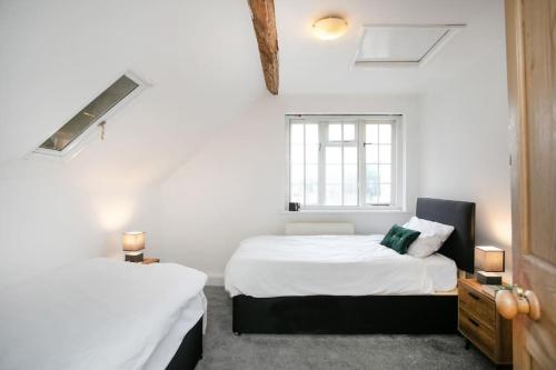 2 camas en una habitación con paredes blancas y ventana en Central 4 Bedroom House en Derby
